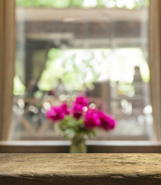 Порожній дерев'яний стіл зверху на розмитій шторі з видом на вікно зеленим з фону саду дерева. Для дисплея продукту монітора або візуального планування ключа дизайну
 - Фото, зображення