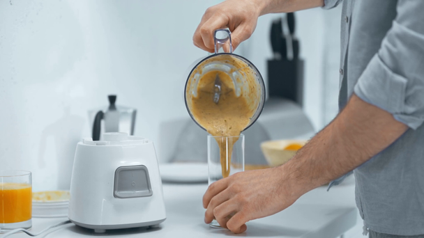 bijgesneden aanzicht van de man opening blender en gieten smoothie in glas - Video