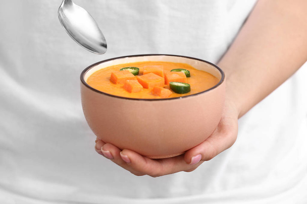 Женщина держит миску вкусного кремового супа, крупным планом
 - Фото, изображение