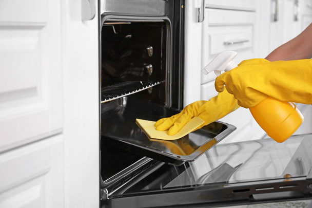 Mujer horno de limpieza en la cocina - Foto, imagen