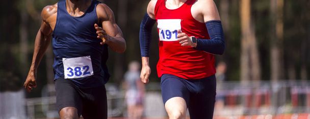 Чоловіки-спортсмени спринтуються. Двоє чоловіків у спортивному одязі біжать на бігу
 - Фото, зображення