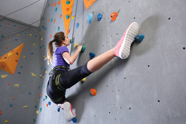 Young woman climbing wall in gym - Photo, Image