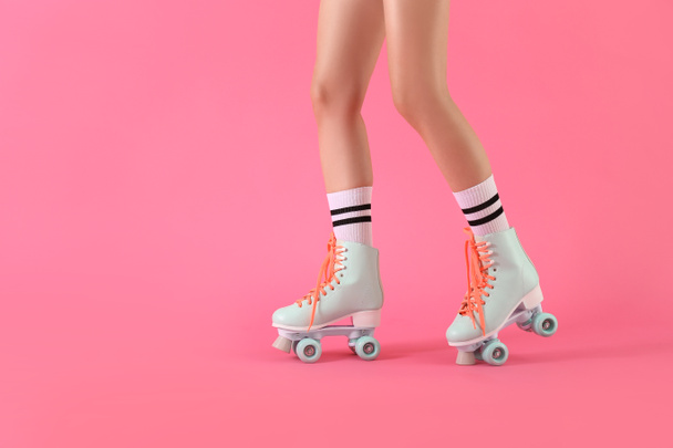 Legs of woman in roller skates on color background - Photo, Image