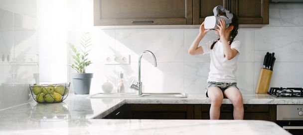 Dziecko dziewczyna za pomocą wirtualnej rzeczywistości okulary w domu - Zdjęcie, obraz