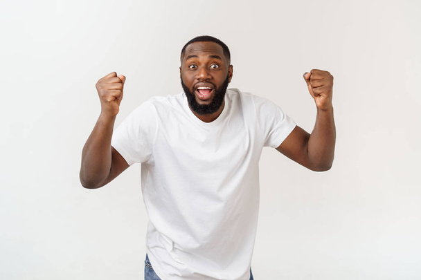 Portrait of a cheerful young man shouting with arms raised in success. - Photo, Image