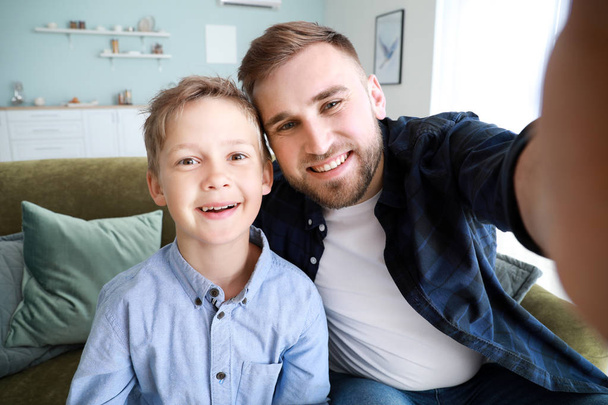 Porträt glücklicher Vater und Sohn beim Selfie zu Hause - Foto, Bild