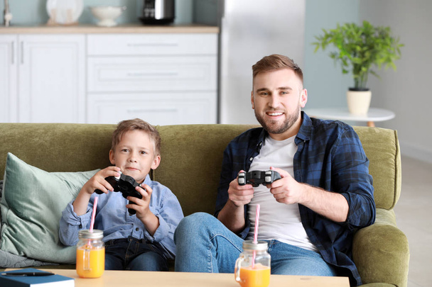 Portrait of father and son playing video game at home - Photo, Image