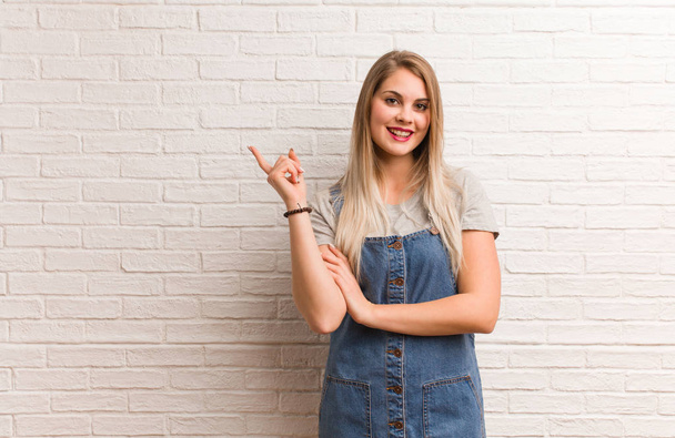 Young russian hipster woman pointing to the side with finger - 写真・画像