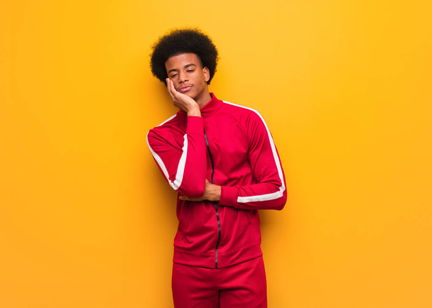 Νεαρός αθλητικός μαύρος πάνω από έναν πορτοκαλί τοίχο κουρασμένος και πολύ νυσταγμένος - Φωτογραφία, εικόνα