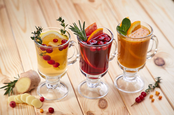 Berry čaj s bylinkami ve skleničkách na dřevěné pozadí, zblízka  - Fotografie, Obrázek