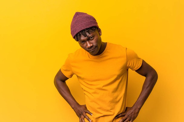 Young black man wearing rastas over yellow background scolding someone very angry. - Fotografie, Obrázek