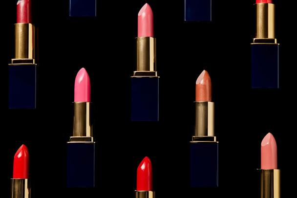 background with different shades of lipsticks isolated on black    - Фото, изображение