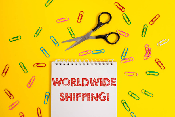 Word writing text Worldwide Shipping. Business concept for Sea Freight Delivery of Goods International Shipment Blank no color spiral notepad scissors clips colored background design. - Photo, Image