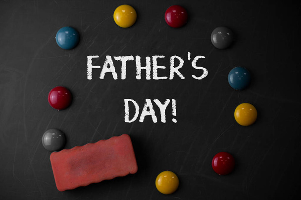 Słowo pisanie tekstu ojciec S Day. Koncepcja biznesowa na dzień roku, w którym Ojcowie są szczególnie honorowane przez dzieci okrągłe płaskie kamienie z jedną gumką trzymać się starej kreda czarna deska. - Zdjęcie, obraz
