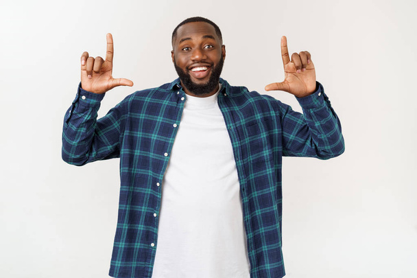 Jeune afro-américain étonné pointant son doigt sur fond blanc avec de l'espace de copie pour votre publicité
 - Photo, image