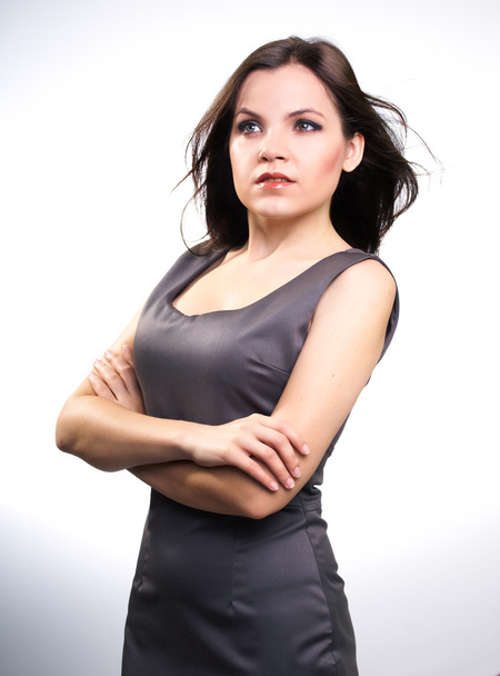 Attraente giovane donna in un abito da lavoro grigio. Indagando
 - Foto, immagini