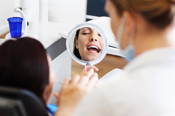 Patient Looking At Mirror While Dentist Showing Her Cavity - Фото, зображення