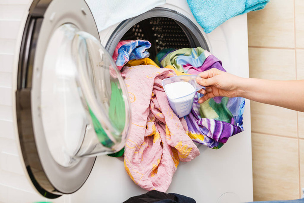 Person putting clothes into washing machine - Photo, Image