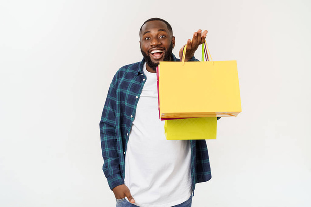 Boldog afro-amerikai ember tartja bevásárló táskák, fehér háttér. Concept ingatlanvásárlás - Fotó, kép