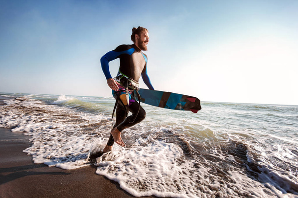 ビーチでサーフィン ボードを持つサーファー男の肖像画。夏のスポーツ - 写真・画像