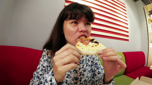 Mladá hladová žena pojídáním pizzy, legrační pomalý pohyb - Záběry, video