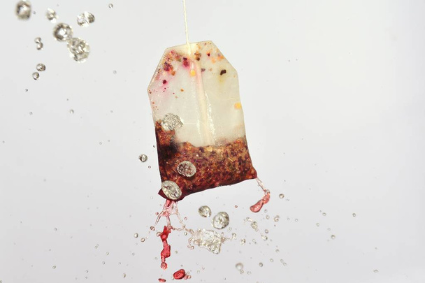 tea bag with water fountain on white background - Fotó, kép