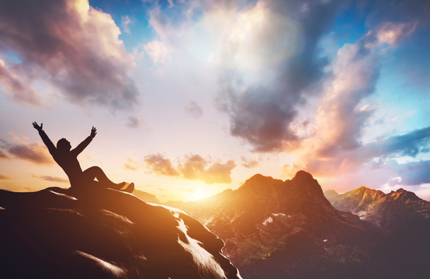 Sylwetka szczęśliwego udanego człowieka na szczycie góry o zachodzie słońca - Zdjęcie, obraz
