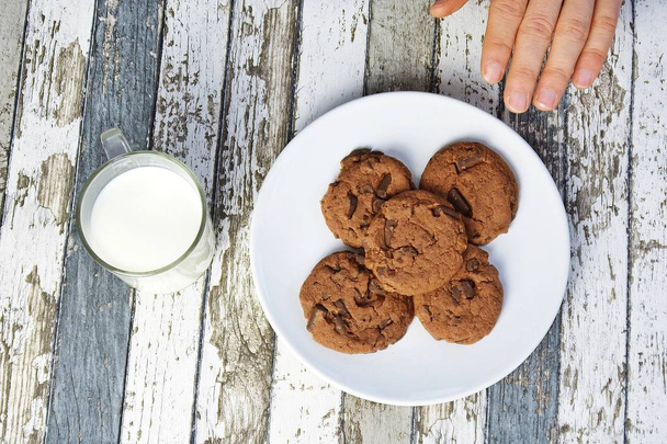їдять печиво і п'ють молоко крупним планом
 - Фото, зображення