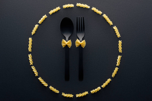 pohled na Vaflové těstoviny na lžičce a vidličku v kruhu od těstovin rotini  - Fotografie, Obrázek