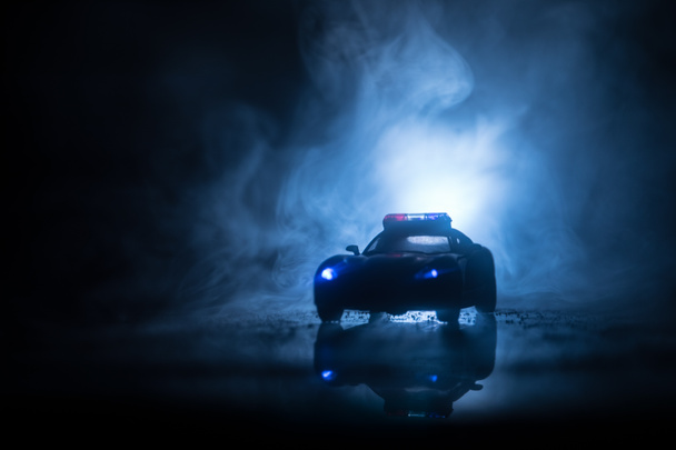 Los coches de policía por la noche. Coche de policía persiguiendo un coche por la noche con niebla de fondo. 911 Respuesta de emergencia
 - Foto, imagen