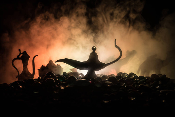 Antiguo Aladdin noches árabes lámpara de aceite de estilo genio con humo blanco claro suave, fondo oscuro
. - Foto, imagen