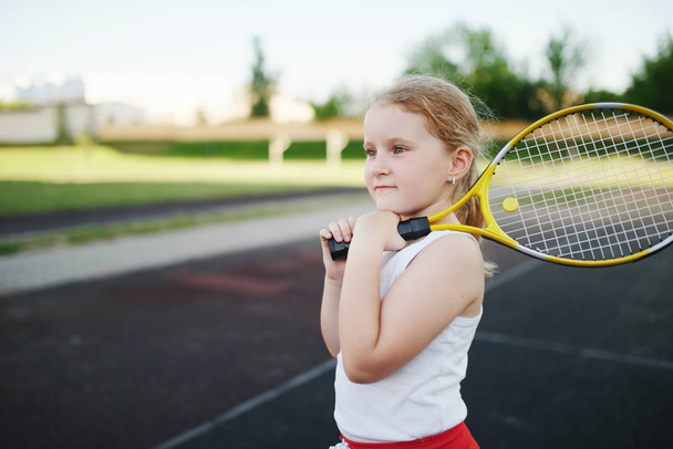 happy girl plays tennis on court outdoors - Φωτογραφία, εικόνα