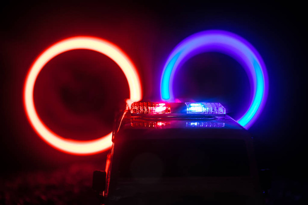 Poliisiautoja öisin. Poliisiauto jahtaa yöllä autoa, jolla on sumutausta. 911 Hätätilanne Valikoiva tarkennus
 - Valokuva, kuva