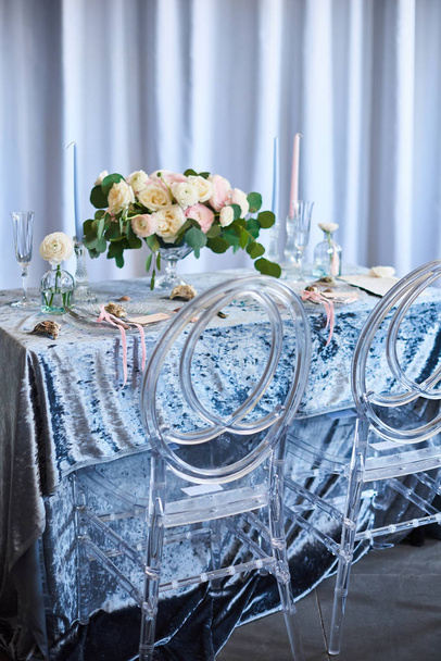 Decoración de boda vintage. Hermoso lugar del evento. Decoración creativa. Color azul, nácar blanco. Mesa con mantel de felpa azul, flores, perlas y conchas marinas
 - Foto, imagen