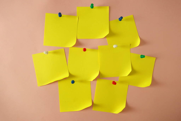 Желтые приколотые липкие ноты с загнутым углом на розовом фоне, копия пространства для дизайна
 - Фото, изображение
