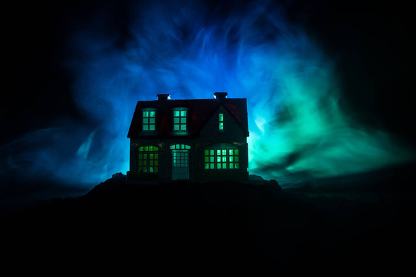 Oud huis met een geest in het bos bij nacht of verlaten Haunted Horror House in mist. Oude mystic gebouw in dode boom bos. Bomen bij nacht met maan. Surrealistisch lichten. - Foto, afbeelding