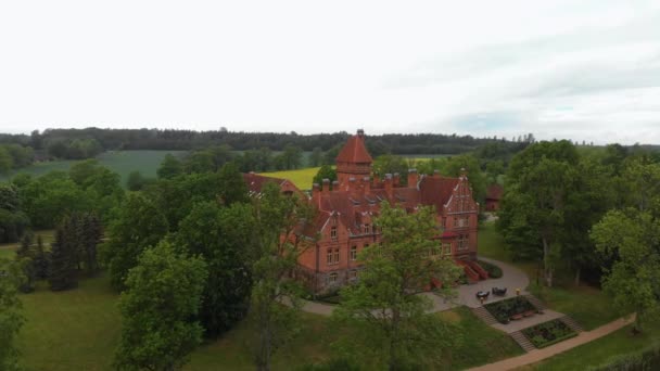 Letonya'da eski Kale malikane üzerinde uçan Hava - Jaunmoku yaz ve çevresinde yeşil ağaçlar sırasında üst görünümünden pils - Video, Çekim