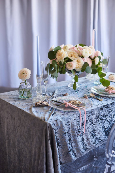 Vintage γαμήλια διακόσμηση. Όμορφος χώρος εκδηλώσεων. Δημιουργική διακόσμηση. Μπλε, λευκό χρώμα. Τραπέζι με μπλε βελούδινο τραπεζομάντιλο, λουλούδια, πέρλες και κοχύλια - Φωτογραφία, εικόνα