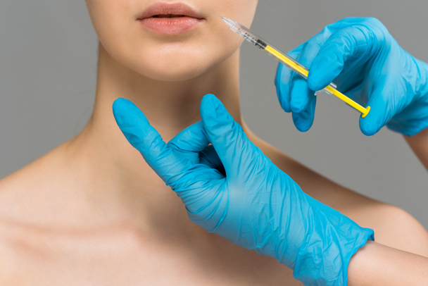 rajattu näkymä plastiikkakirurgi tekee kauneus injektio alaston nainen eristetty harmaa
  - Valokuva, kuva