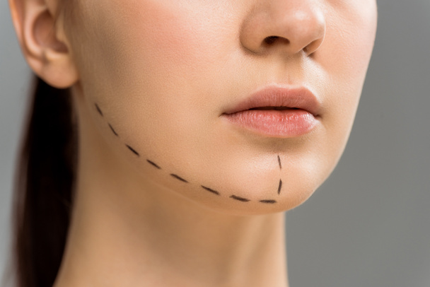 vista cortada de mulher jovem com marcas no rosto isolado no cinza
  - Foto, Imagem