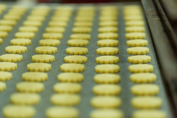 Produktion von Shortbread-Keksen. Zubereitung von Keksen in einer Bonbonfabrik. süßes Dessert.  - Foto, Bild