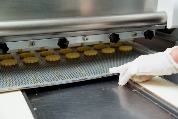 Productie van zandkoekjes cookies. Voorbereiding van cookies in een snoepfabriek. Zoete dessert.  - Foto, afbeelding