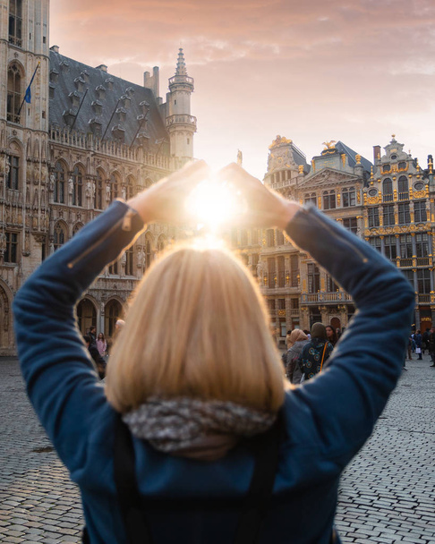 Woman stands in the square Grand Place in Brussels, Belgium at sunset. - Foto, Imagem