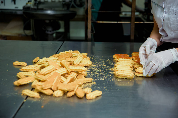 Producción de galletas dulces de pan corto. Preparación de galletas en una fábrica de dulces. Postre dulce con leche condensada hervida
. - Foto, imagen