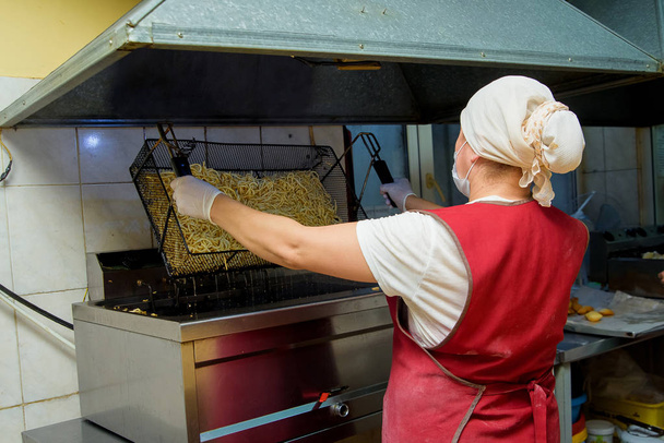 A nő főtt tésztát húz elő desszertnek Chuck-Chuck. Péksütemények készítése a cukrászdában. Édes mazsolás tészta desszert. - Fotó, kép