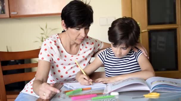 Мать средних лет помогает дочери с домашним заданием
. - Кадры, видео