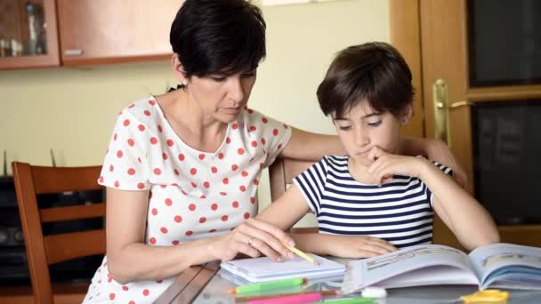 Middle-aged mother helps her daughter with her homework. - Footage, Video