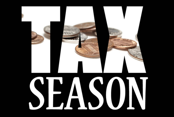 Inscripción temporada de impuestos con monedas en el interior sobre fondo negro
 - Foto, imagen