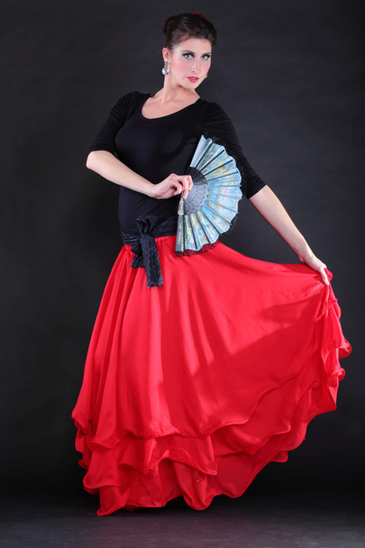 Attractive spanish young woman dancing flamenco over black backg - Fotó, kép