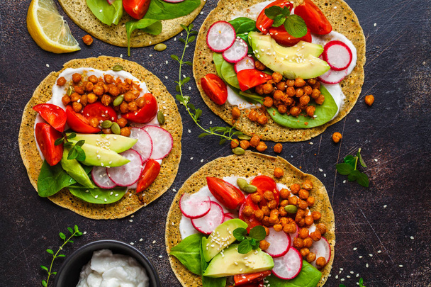 Vegan tacos with baked chickpeas, avocado, sauce and vegetables  - Фото, зображення
